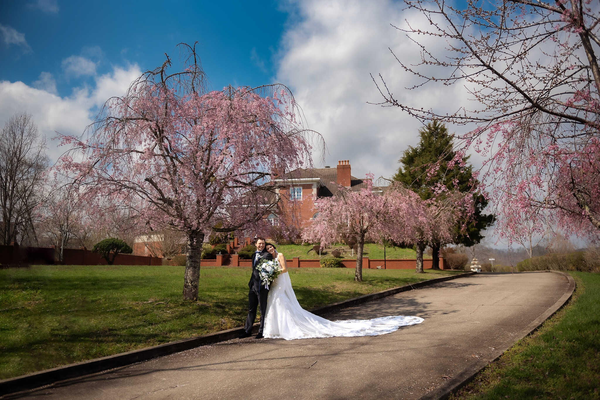 Kentucky Wedding Photographer Man in tux standing with woman in vintage wedding gown with long train, in front of mansion